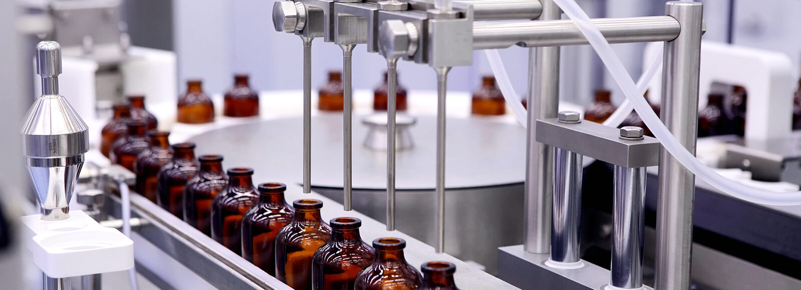 Automated filling line dosing liquid into amber glass bottles